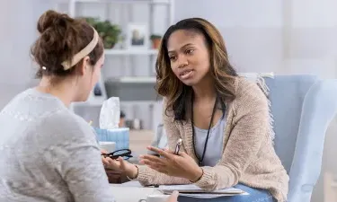 Substance Abuse Counselor with Psychology Degree Smiling with Client